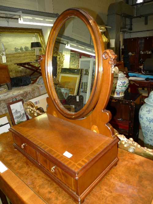 An inlaid mahogany dressing mirror with oval plate above base drawer