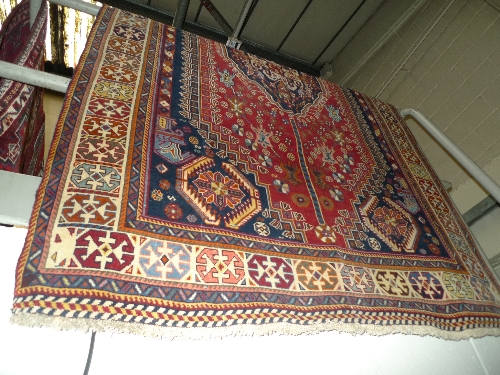 A fine South West Persian Qashgai carpet 245cm x 160cm the red field of tribal motifs around a pole