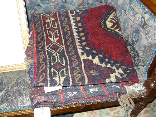 An Afghan hand knotted rug with geometric pattern on red field and one other