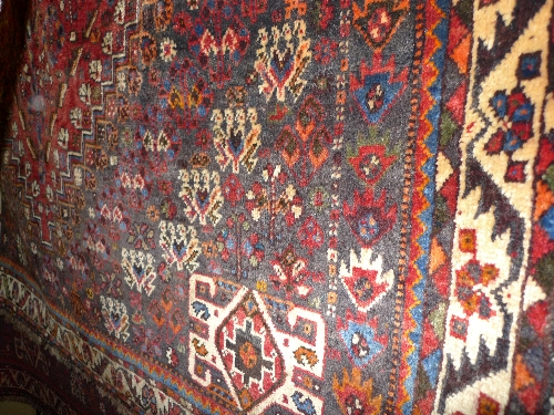 A fine South West Persian Qasghai carpet the red field of tribal motifs around a stepped ivory