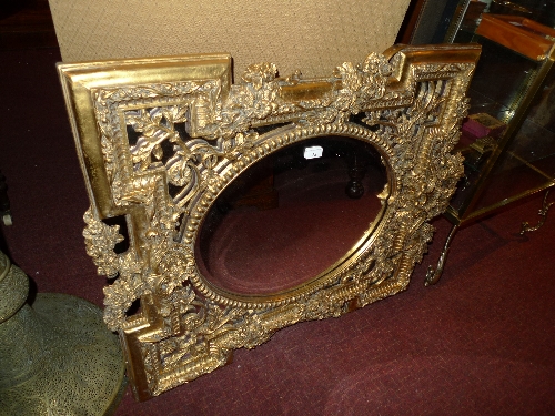 A French style aperture mirror the oval plate in ornate gilt frame