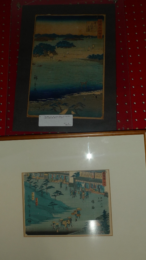 Two antique Japanese woodblock prints one of a coastal scene the other a street scene