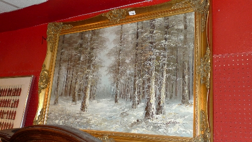 An oil on canvas winter forest scene signed Whitman in a gilt frame