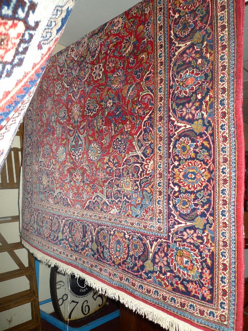 A fine Persian silk rug the red field with stylized foliate decoration within a similar border