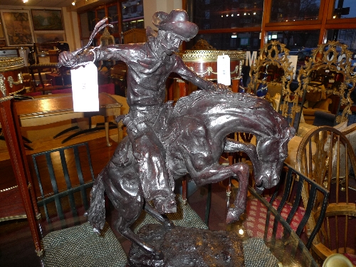 A bronze in the style of Remington rodeo cowboy on horseback
