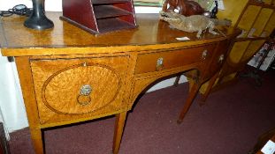 A C19th birds-eye maple bowfront sideboard with central drawer flanked by cellarette drawers