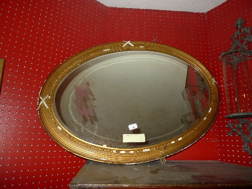 A C19th looking glass the oval plate in reeded giltwood frame