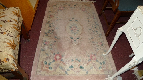 A Chinese rug the ivory field with rose head foliate decoration