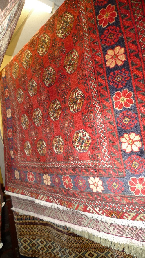 A fine North East Persian Turkoman rug 215 cm x 130 cm repeating Goul motifs on a terracotta field