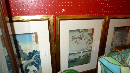 A set of three Japanese woodblock prints of landscape scenes in gilt frames
