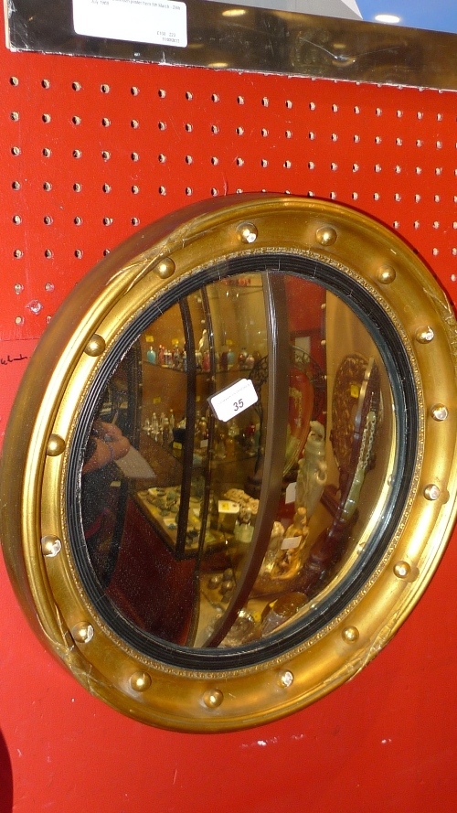 A circular convex mirror in gilt ball frame