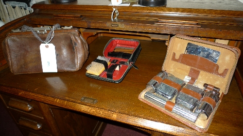 Two cased gentlemans travelling vanity sets together with a leather bag