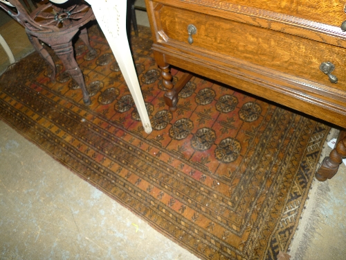 A hand knotted Bokhara rug the yellow ground with ghoul motifs within multi border