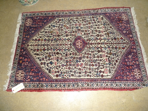 A small hand knotted Persian rug red and cream fields with repeating foliate motifs