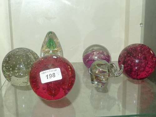 A collection of five coloured glass paperweights