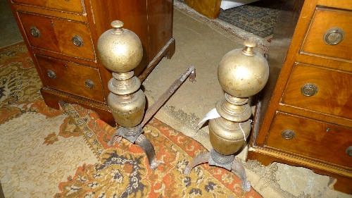 A pair of C19th cast iron and brass fire dogs