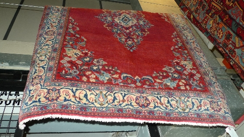 A fine North West Persian Sarouk rug 157cm x 107 cm pendent medallion on a rouge field within floral