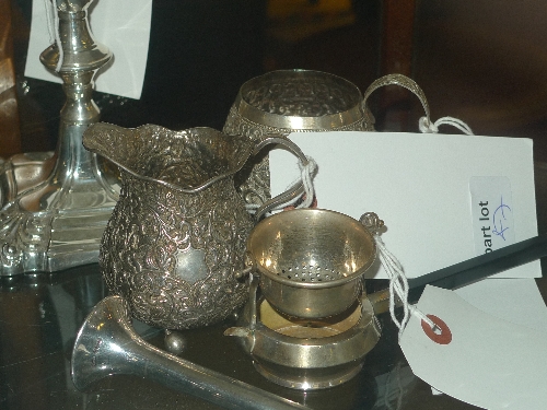 A hallmarked silver tea strainer and two white metal jugs