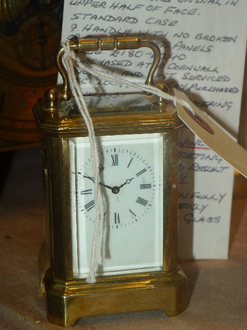 A brass miniature carriage clock with enamel dial