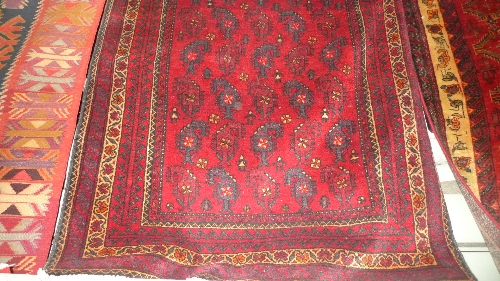 A fine North East Persian Mesham Belouch rug 220cm x 112cm repeating zile sultan motifs on a rouge