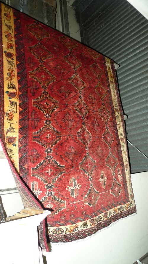 A fine North East Persian Turkoman rug 217cm x120cm repeating pole motifs on a templated field