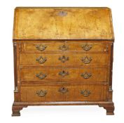 A George II walnut bureau, circa 1735, the hinged rectangular fall opening to a fitted interior