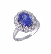 A tanzanite and diamond cluster ring, the oval modified cut tanzanite, estimated to weigh 2.95