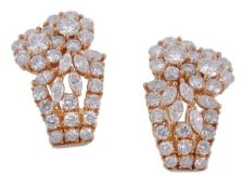 A pair of diamond ear clips, each pediment with a pair of diamond flower head clusters to marquise