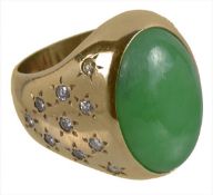 A jadeite and diamond dress ring, the oval cabochon jadeite panel, 1.9cm long, to a polished