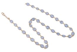 An aquamarine necklace, the 34 graduating oval cut aquamarines within 18 carat yellow gold