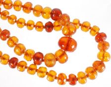 Two amber bead necklaces, the first consisting of seventy 7.5mm - 20mm graduated faceted beads of