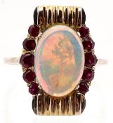 An opal and ruby dress ring, the oval cabochon opal between two rows of graduated round cut rubies,