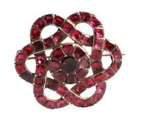 A Georgian garnet brooch, circa 1800, the brooch in the form of a lovers` knot, the garnets with