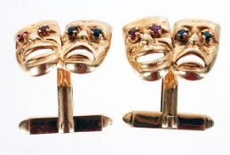 A pair of 9 carat gold cufflinks, formed in the shape of tragedy and comedy masks, the eyes set