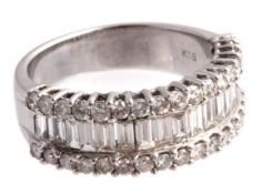 A diamond ring, the ring with a central row of baguette cut diamonds between two rows of brilliant