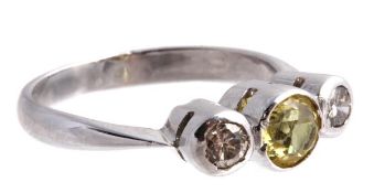 A yellow sapphire and diamond three stone ring, the round cut yellow sapphire between two brilliant