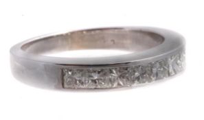 A diamond half eternity ring, set with nine princess cut diamonds in a channel setting,