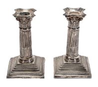 A matched pair of silver dwarf Corinthian candlesticks by Barker Brothers, Chester 1914 and