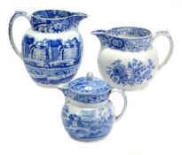 Three Spode blue and white printed pottery Dutch jugs including a covered example, the largest 18.