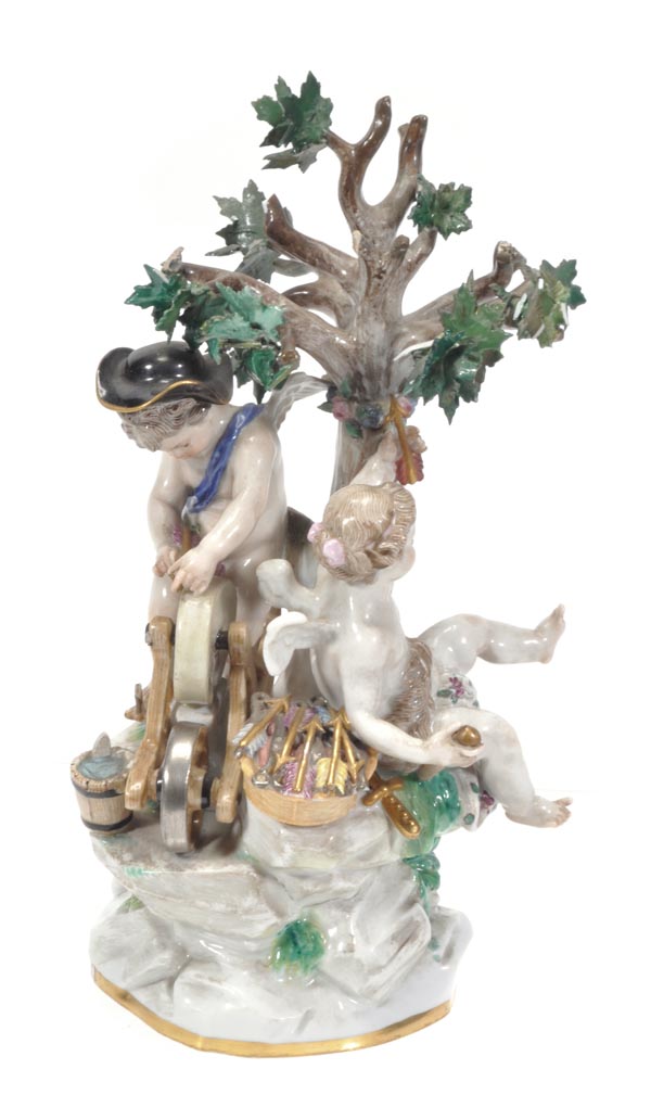 A Meissen group of Cupid and another putto, modelled beneath a tree fashioning arrows, 20cm high,