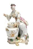 A Chelsea chinoiserie bouquetiere figure of a lady, modelled seated beside a pierced urn, sparsely