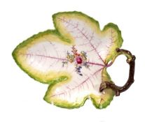 A Chelsea leaf-shaped dish, twig handle, painted with a central floral spray, green/yellow rims,