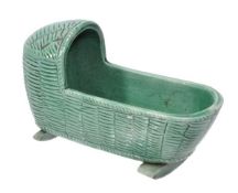 A Staffordshire pearlware green-glazed ozier-moulded model of a cradle, supported on two rockers,