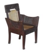 A Ceylonese teak and caned armchair, circa 1900, profusely carved with foliage, with caned back and