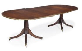 A mahogany and gilt mounted twin pedestal dining table, in Regency style, with an additional leaf,