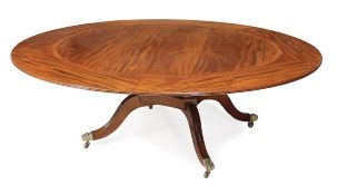 A circular mahogany concentric extending dining table, of recent manufacture, with five curved