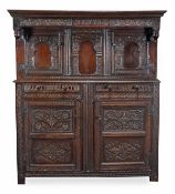 An oak press cupboard, late 17th/early 18th century, the moulded cornice above the acanthus carved