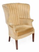 An upholstered tub armchair in George III style, high fluted back, scroll arms and cushion seat, on