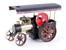 A Wilesco live steam Allchin traction engine, black with polished brasswork and a red flywheel,