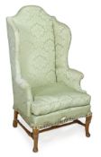 A green damask upholstered and stained oak wing armchair, in George II style, early 20th century,